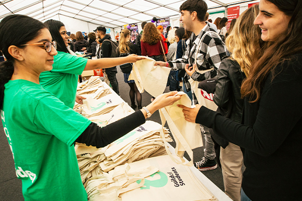 Guild staff giving out free tote bags to students