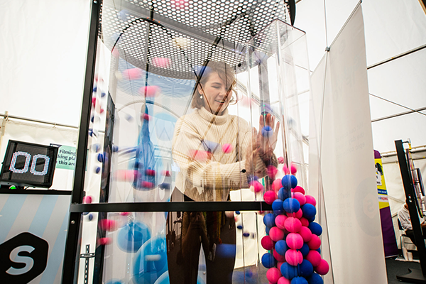 Student in a tube filled with balls