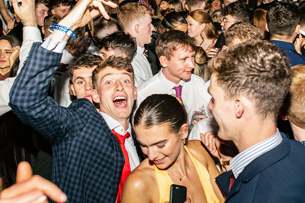 students at a club night in dresses and suits