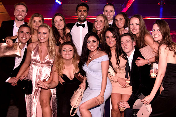 students at a club night in dresses and suits