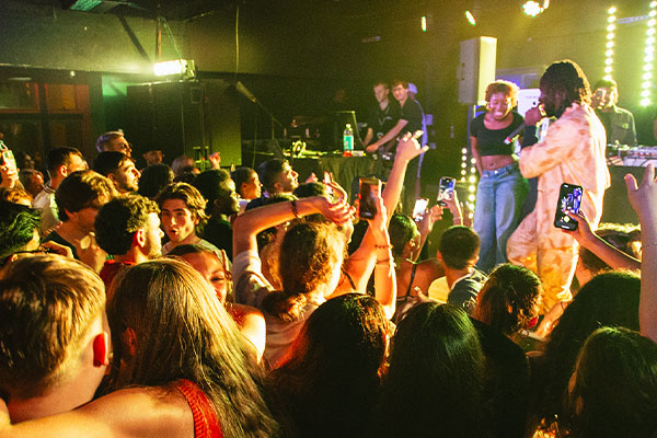 students dancing with a singer performing on stage