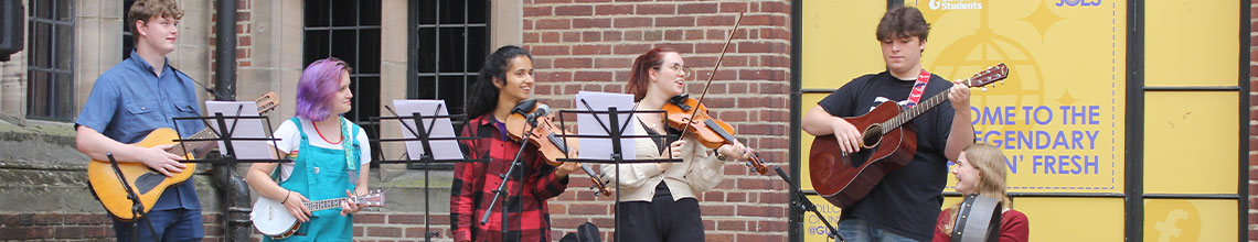 a picture of students in a band performing in guild square