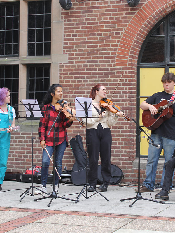 a picture of students in a band performing in guild square